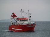 Red fishing vessel at sea